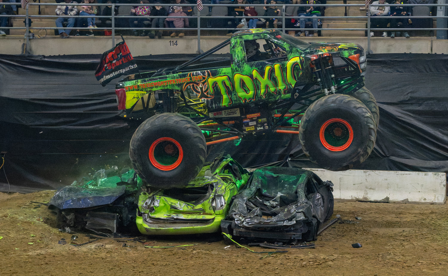 Toxic Monster Truck crushing junk vehicles during a freestyle performance